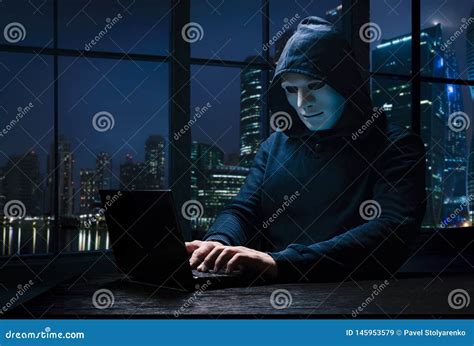 Masked Hacker Wearing A Balaclava With Laptop Stealing Importance Data