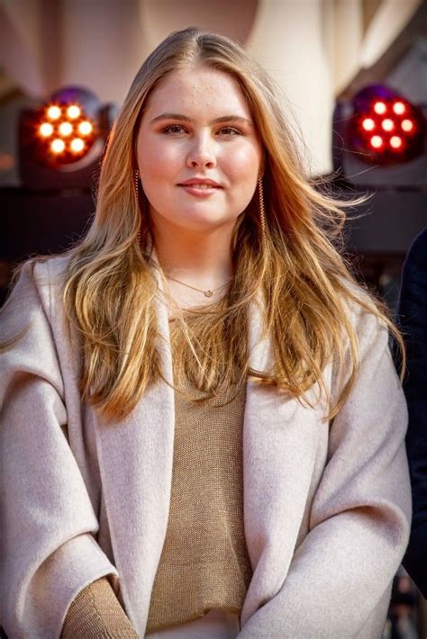 A Woman Standing In Front Of Two Red Lights With Her Arms Crossed And