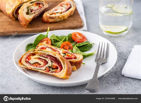 Italian Food Pizza Roll Stromboli With Cheese Salami Spinach And Red Pepper A Light Background