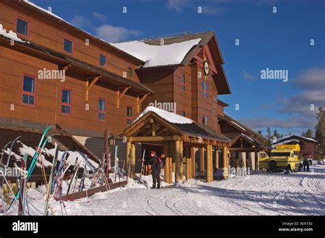 Old Faithful Snow Lodge in winter with snow coach and skis at entrance ...