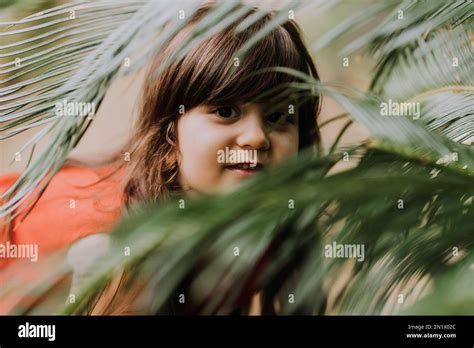 Cute Brunette Girl In A Red Dress Walks In Summer Among Palm Trees In The Park High Quality