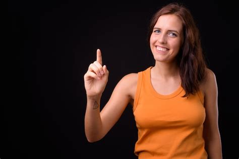 Mujer Hermosa Joven Contra La Pared Negra Foto Premium