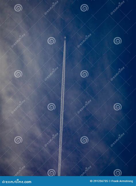 Airplane At High Altitude Flying In Cirrus Clouds With A Contrail Stock