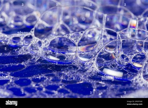 A Closeup Of Blue Translucent Soap Bubbles Floating On The Water