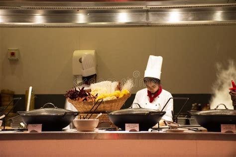 Chef And Assistant Chefs Cooking And Prepared Buffet Food At Restaurant