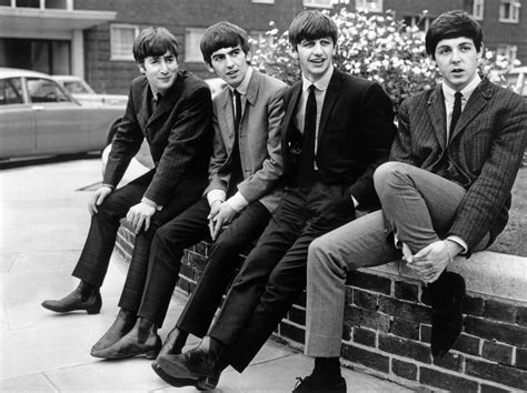 The Beatles Pose Sitting On A Wall Left To Right John Lennon George