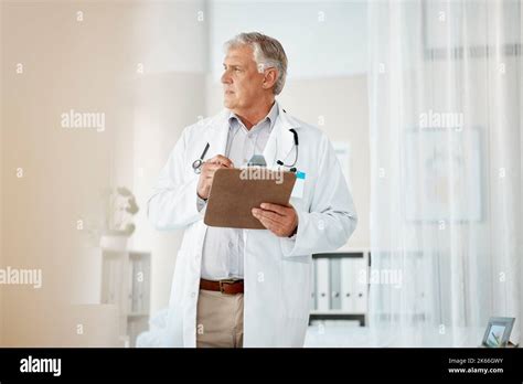 Pensive Mature Male Caucasian Doctor In White Lab Coat Looking Out