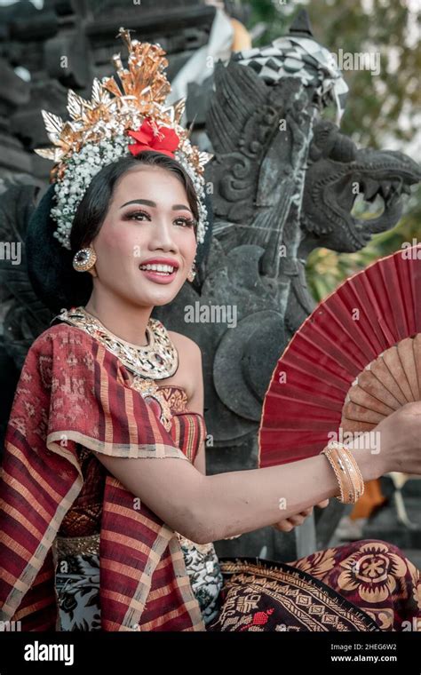 Portrait Bali Girl With A Traditional Dress Standing With Folding Fan