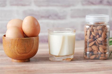 Premium Photo Eggs In A Bow Almond Nuts And A Glass Of Milk On Table