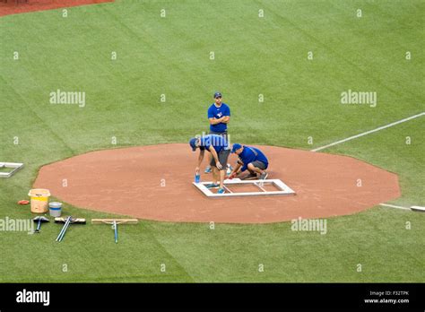 Grounds crew chalk in the batters box at the home plate area for a ...