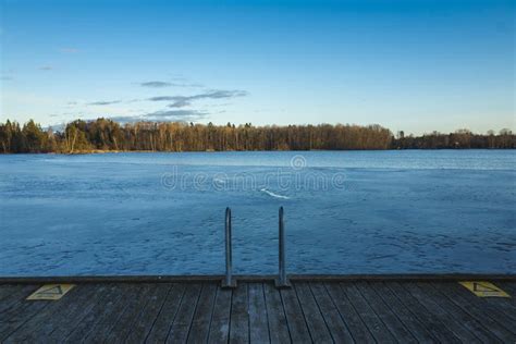 Frozen Lake With Ice And Wood Bridge In Sweden At Spring Evening Stock