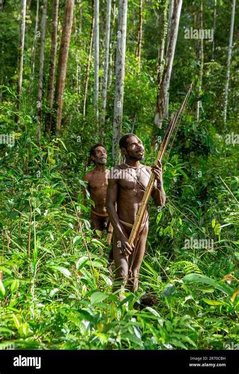 Los hombres de la tribu Korowai están regresando de la caza Tribu de