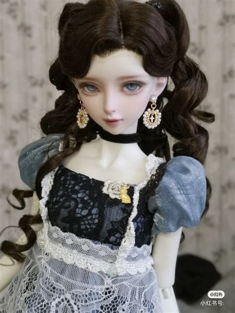 A Doll With Long Brown Hair Wearing A Black And White Dress