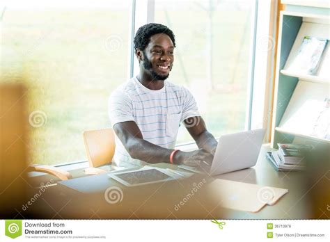 Estudante Using Laptop While Que Estuda Na Biblioteca Foto De Stock