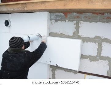 Builder Installing Rigid Styrofoam Insulation Board