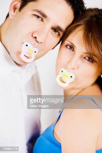 Portrait Of A Mid Adult Man And A Young Woman Sucking Pacifiers High