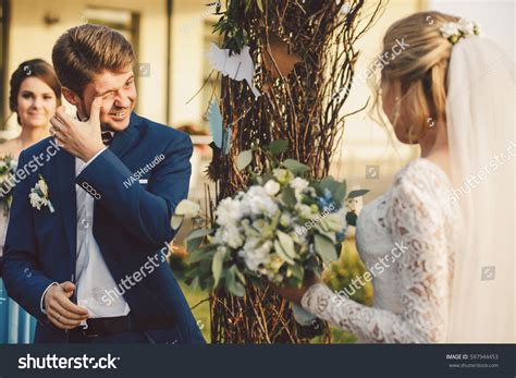 groom touches  eye crying  stock photo  shutterstock