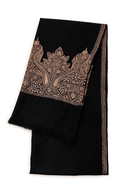 a black and gold scarf with an intricate design on the front, sitting ...