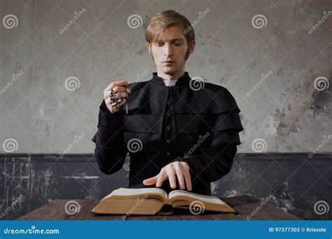 Portrait Of Handsome Young Catholic Priest Praying To God Stock Image