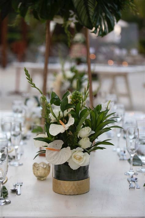 Small Tropical Centerpieces With White Flowers And Greenery