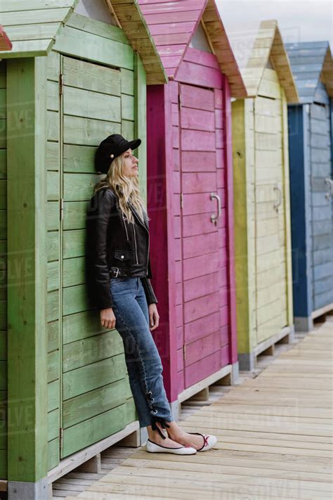 Trendy Long Haired Blonde Woman In Black Cap And Leather Jacket Smiling