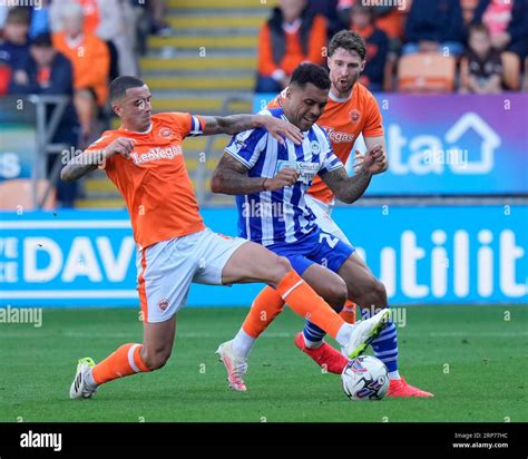 Oliver Norburn Of Blackpool Competes For The Ball With Josh Magennis