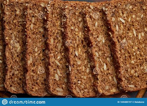 Toasted Rye Grain Bread On A Wooden Cutting Board On Dark Brown