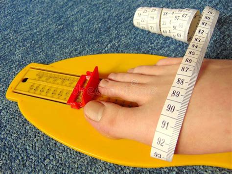 Yellow Foot Measurement Device With Naked Foot Upon With Measuring Tape