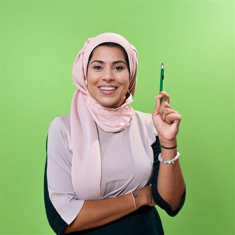 Uma Mulher Segurando Uma Caneta Na M O E Um Fundo Verde Foto Premium