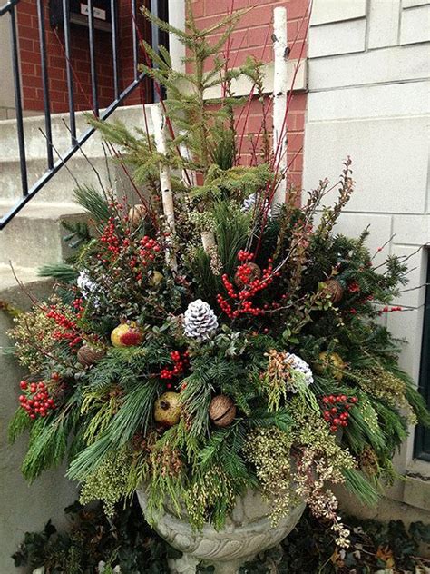 Christmas urn with very full mixed greenery, pine cones, ornaments ...