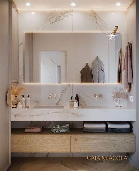 A Bathroom With Marble Counter Tops And White Walls Lighted By