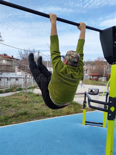 A Man Hanging on a Horizontal Bar on a Street Sports Ground Stock Image - Image of athlete ...