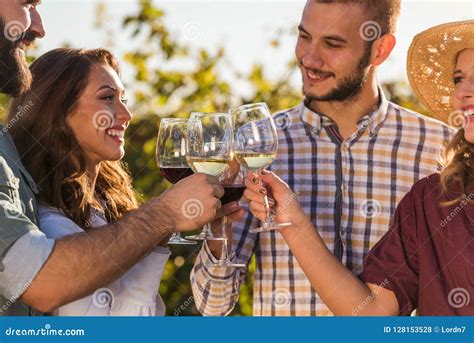 Group Of Young People Tasting Wine In Winery Near Vineyard Stock Photo