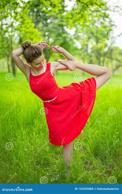 La Belle Fille Mince De Brune Dans Une Robe Rouge Exécute Des Poses De