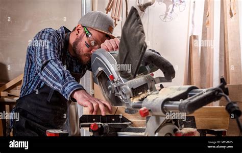 Experienced Carpenter Using Circular Saw For Cutting Wooden Boards