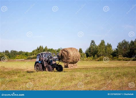 Belarus Tractor Works In The Field Collecting Straw Stock Image