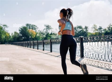 Back View Of Fit Woman Running Outdoors By River Beautiful Woman In