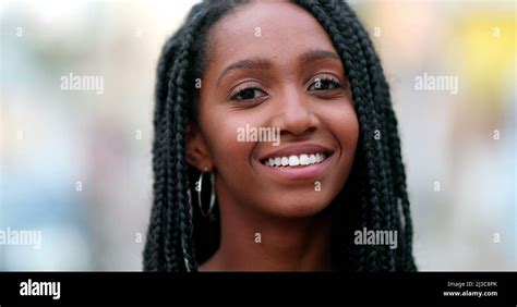 Portrait black African teen girl smiling at camera. Young woman face