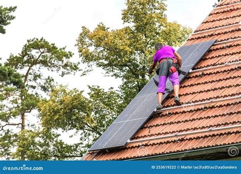 Man Installing New Solar Panels On The Roof Of A Private House