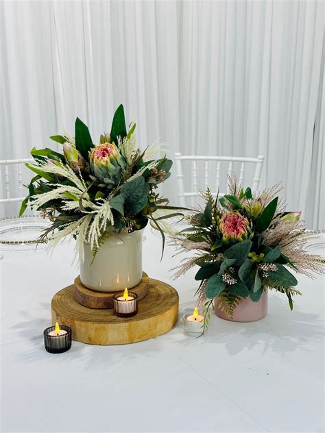 Pink And Grey Glass Vases With Silk Native Arrangement On Tree Trunk