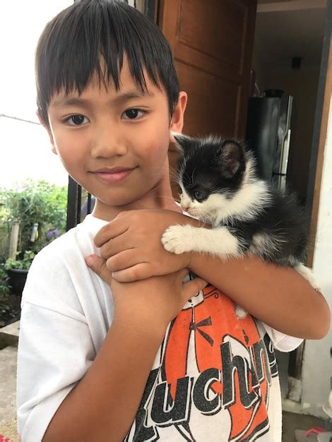 Premium Photo Portrait Of Smiling Boy Holding Kitten