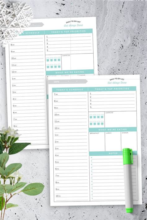 two printable daily planner pages on top of a table next to a potted plant