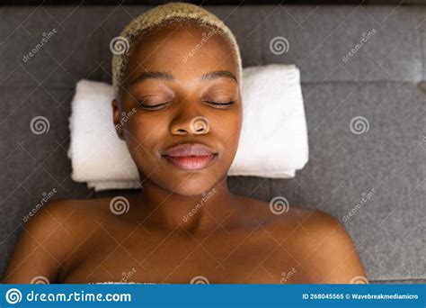 Happy African American Woman Lying On Towel With Eyes Closed Stock