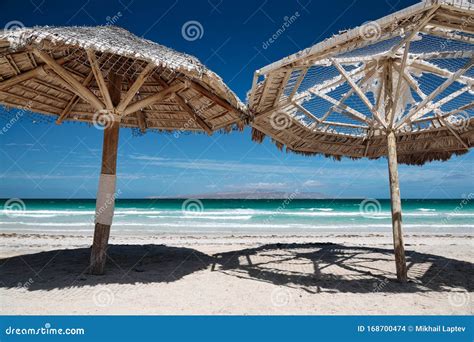 Grandes Sombrillas De Madera En Una Playa Tropical De Arena Foto De