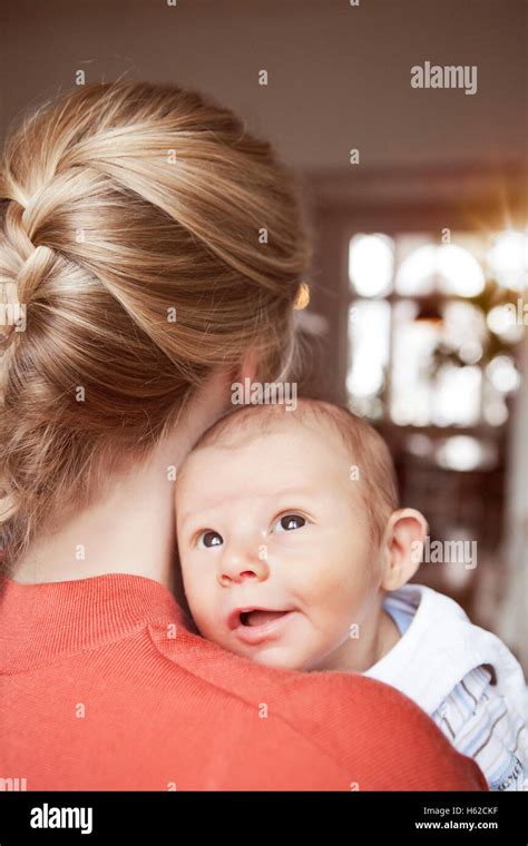 Baby Looking Over Shoulder Of Mother Stock Photo Alamy