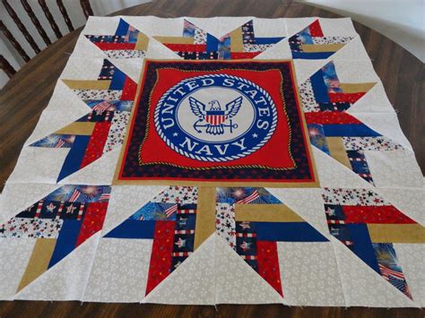 A Quilted Table Topper With An Eagle And The Words United States Navy On It