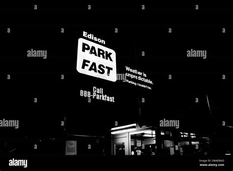 A grayscale of a busy car park entrance illuminated at night Stock Photo - Alamy