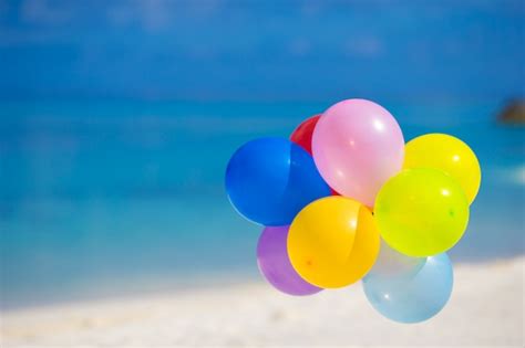 Premium Photo | Multicolored balloons on white tropical beach