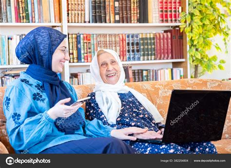 Happy Muslim Grandmother Her Granddaughter Sitting Together Couch Using