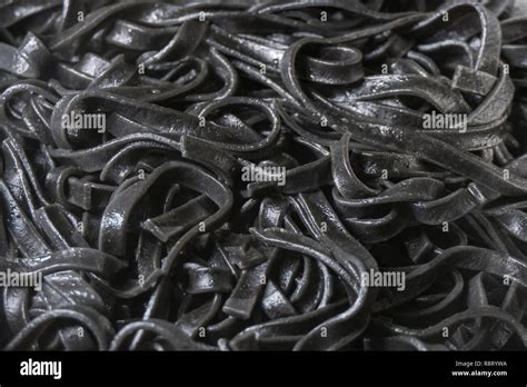 Black squid ink pasta fettuccine cooked background Stock Photo - Alamy